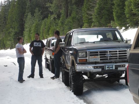1989 Ford Bronco - A lifted 1989 Ford Bronco is parked in the snow with two other vehicles visible behind it.