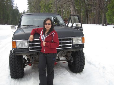 1989 Ford Bronco - A person poses in front of a lifted black Ford Bronco in a snowy, wooded area.