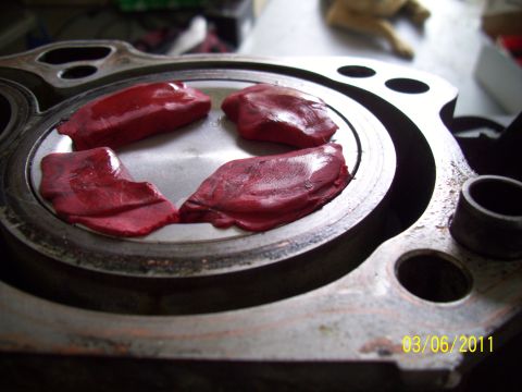 1995 Ford Probe - Engine cylinder head with red clay applied to piston tops, likely for valve clearance testing.