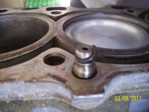 1995 Ford Probe - Close-up of an engine's cylinder head, showing a piston within one of the bores and a small valve component. A date stamp is visible in the…