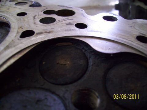 1995 Ford Probe - Close-up of an engine cylinder head with visible valves and bolt holes.