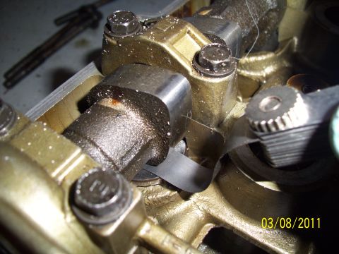 1995 Ford Probe - Close-up view of an engine's valve train, showing a shim and rocker arm assembly.