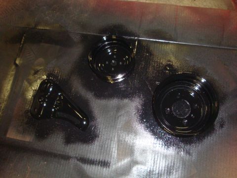 1989 Ford Bronco - Painted brake rotors and caliper bracket are laid out on a metal surface.