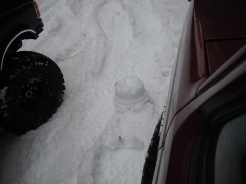 1991 Ford Bronco - Two vehicles are parked in a snowy area, with one tire visible on the left.