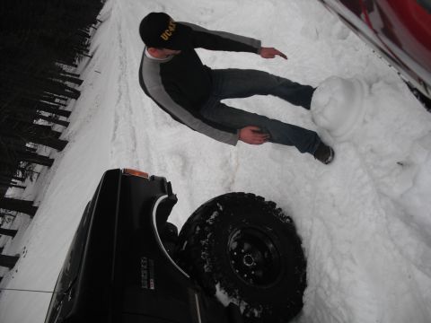 1991 Ford Bronco - A person stands in the snow next to a black SUV, with another vehicle visible in the background.