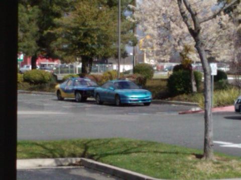 1995 Ford Probe - Two Ford Probes are parked next to each other in an outdoor lot with trees in the background.