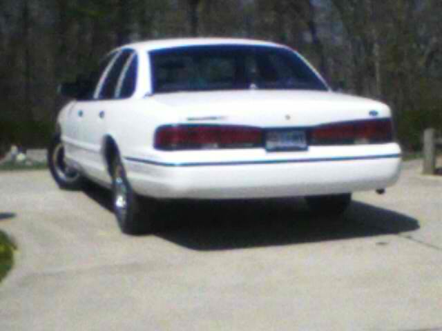 Rear view of a white sedan parked on a concrete surface