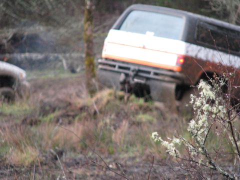 1978 Ford Bronco - 1978 Ford Bronco navigating muddy terrain, with another vehicle partially visible.