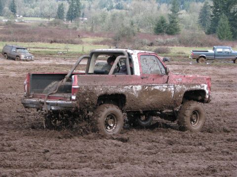 1978 Ford Bronco - Several vehicles are stuck in the mud during an off-road event.