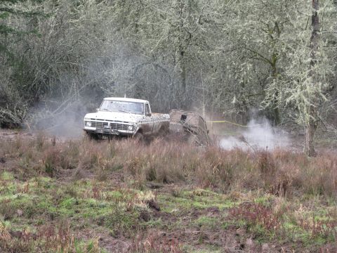 1978 Ford Bronco - Pickup truck navigating a muddy terrain with a trailer in tow.