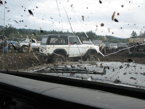 1978 Ford Bronco - Multiple off-road vehicles are stuck in the mud during an event.