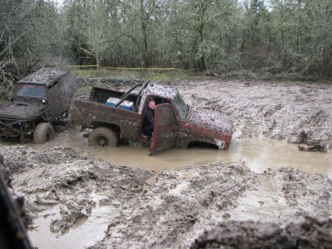 1978 Ford Bronco - Two off-road trucks are stuck in deep mud during an off-road event.