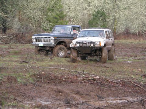 1978 Ford Bronco - Two modified 4x4s navigate a challenging muddy off-road course.