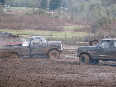 1978 Ford Bronco - Several trucks are stuck in the mud during an off-road event.