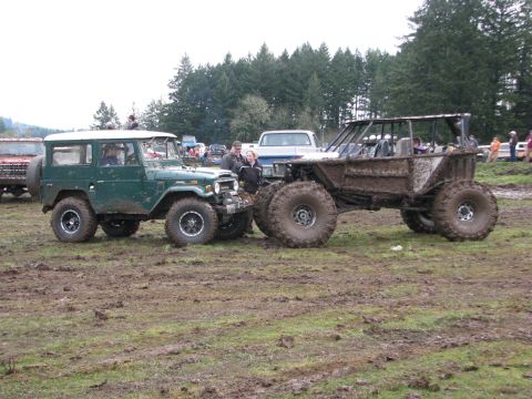 1978 Ford Bronco - Two off-road vehicles, a classic Toyota Land Cruiser and a custom mud bogger, are stuck in the mud.