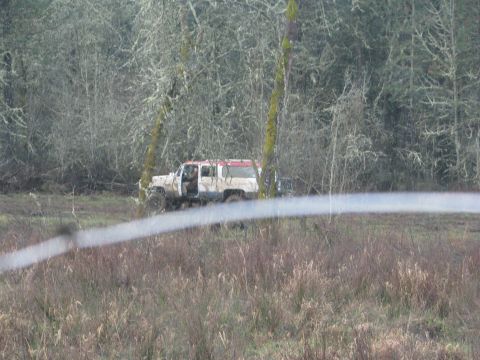 1978 Ford Bronco - SUV stuck in a muddy field with trees in the background.