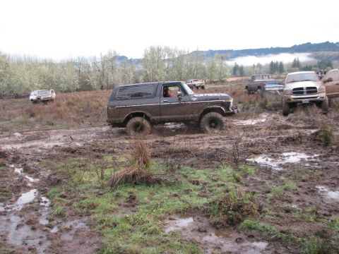 1978 Ford Bronco - A 1978 Ford Bronco struggles through deep mud alongside other off-road vehicles in a challenging terrain.