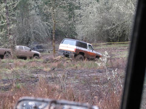 1978 Ford Bronco - Two off-road vehicles are stuck in the mud on a wooded trail.