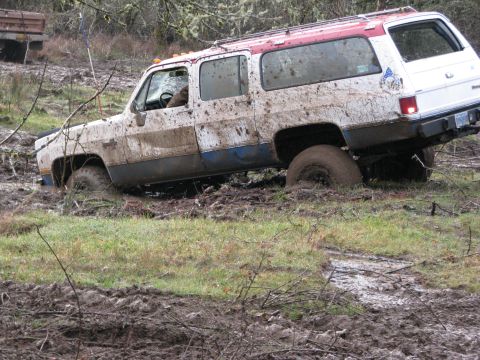 1978 Ford Bronco - This large SUV is deeply stuck in thick mud and appears to be off-roading.