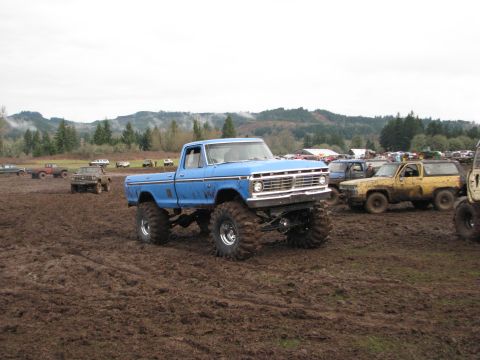 1978 Ford Bronco - Modified pickup truck participating in a mud bogging event with other vehicles present.