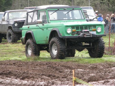 1978 Ford Bronco - This lifted green SUV is equipped with a winch and large off-road tires, ready for muddy terrain.