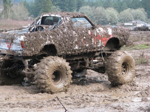 1978 Ford Bronco - This heavily modified truck is caked in mud, making identification of its original make and model difficult.