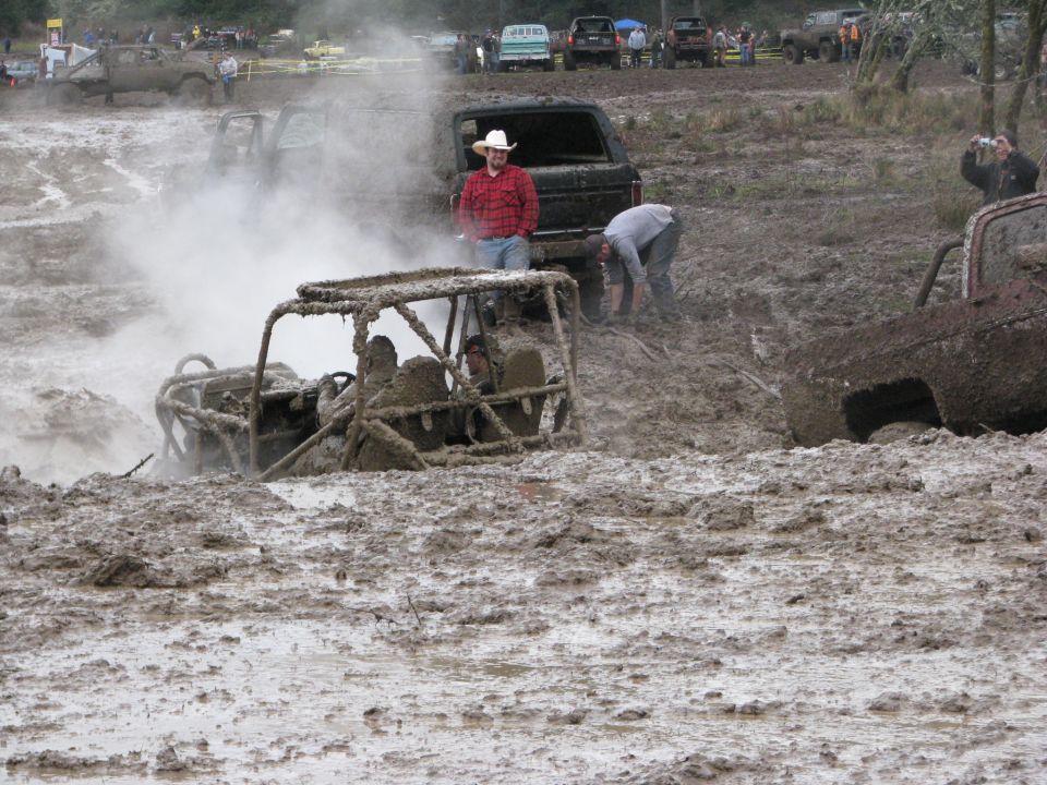 Off-road buggy stuck in mud with people around