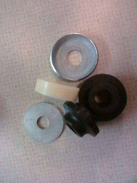 1995 Ford Bronco - A collection of assorted automotive hardware, including washers and bushings, is displayed on a textured background.