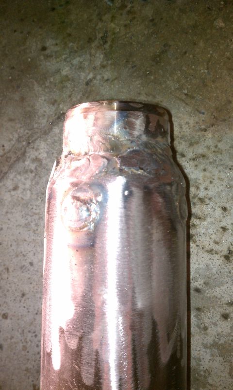 1990 Ford Bronco - A close-up view of a metal pipe, showing rough welds and a brushed metal finish.