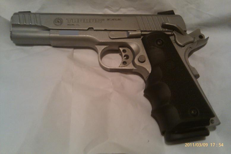 Silver Taurus pistol with black grip
