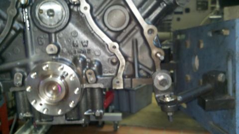 2002 Ford Excursion - Close-up of an engine block with various metal components and fasteners attached.