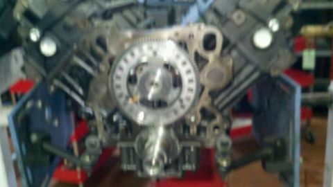 2002 Ford Excursion - Close-up of an engine block's timing gear assembly, with the Supermotors logo visible in the lower right corner.