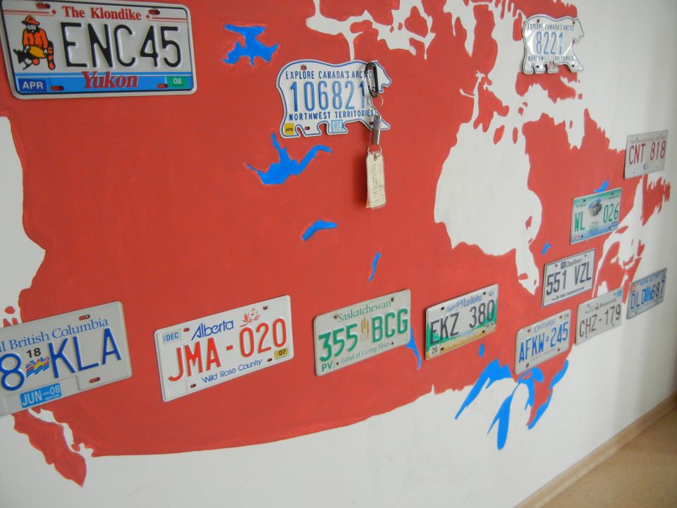 Canadian map mural with license plates from various provinces and territories. Keys hang from one plate