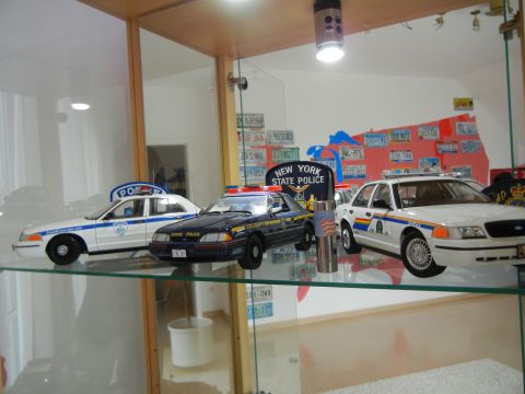 1999 Lincoln Town Car - Several model police cars are displayed on a shelf, including a 1999 Lincoln Town Car.
