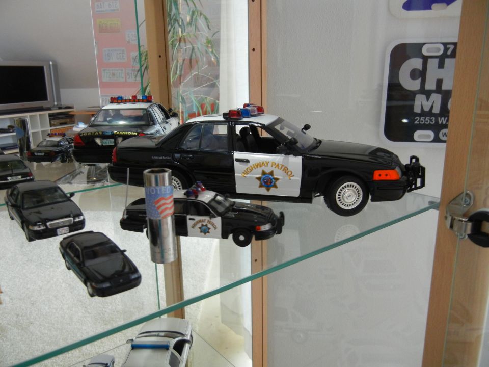 Model police cars on display shelves, one with "HIGHWAY PATROL" text
