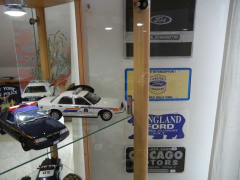 1999 Lincoln Town Car - Several police car models are displayed in a cabinet, including a white sedan and a blue SUV.