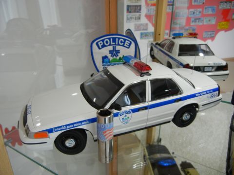 1999 Lincoln Town Car - Model police cars are displayed, one with a 'VOTER' sticker and American flag design.