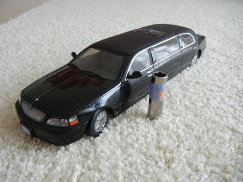 1999 Lincoln Town Car - A black limousine model is shown on a white carpet, next to a socket tool with a vote design.