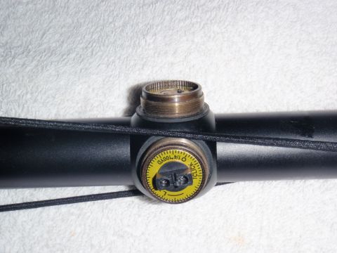 1991 Ford Bronco - Close-up of a telescopic sight's adjustment dial, marked with increments for aiming.