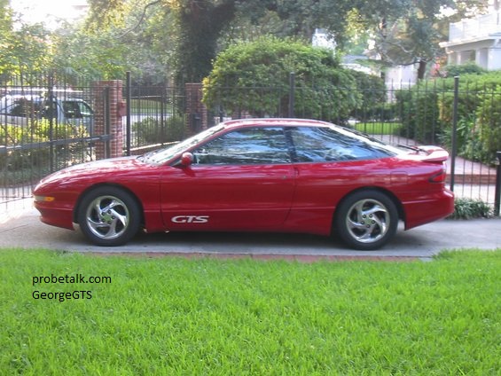 Red Ford Probe coupe in profile with GTS rocker graphics and polished alloy wheels