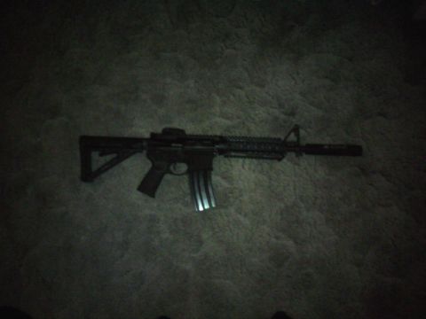 2006 Mazda 6 - An assault rifle is shown on a carpeted floor, with a silencer attached to the barrel.