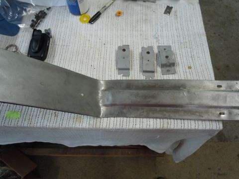 1970 Chevrolet Camaro - A metal car part, possibly a bumper section, lies on a white cloth with mounting brackets nearby.