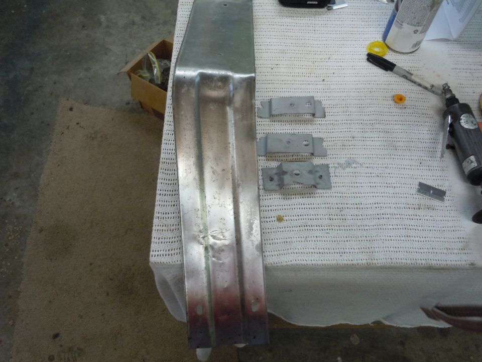 Metal car bumper with mounting hardware on a table