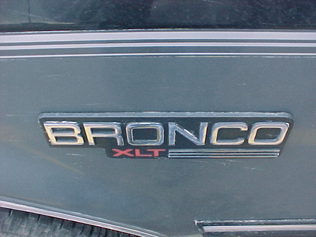 Close-up of a Bronco XLT emblem on a dark-colored vehicle