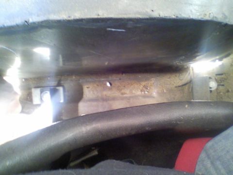 1989 Ford Bronco - Close-up of a vehicle's interior floor pan and seat mounting hardware.