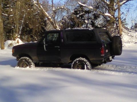 1989 Ford Bronco - 1989 Ford Bronco partially buried in snow during winter conditions.