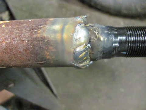 1989 Ford Bronco - This photo shows a close-up view of a rusty metal rod that has been welded to a threaded metal component.