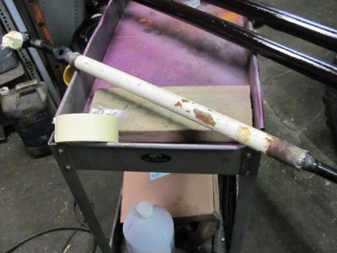 1989 Ford Bronco - A close-up of a vehicle steering component, possibly a drag link, is shown on a cart.