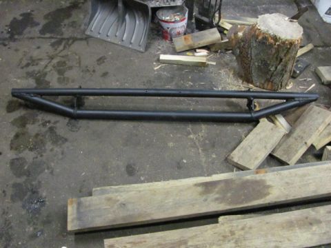 1989 Ford Bronco - Aftermarket rock sliders are shown on a workshop floor, not attached to a vehicle.