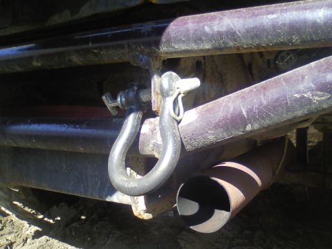 1989 Ford Bronco - Close-up of a vehicle's rear bumper showing a tow hitch shackle and exhaust pipe.